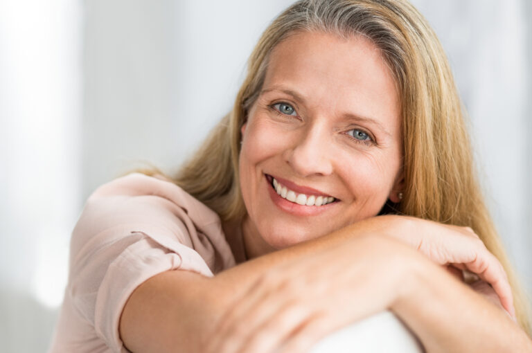 fornøyd kvinne smiler hos trondheim kosmetiske hudpleieklinikk etter å ha tatt fillers